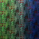 A flat-lay view of a Fijian Tapa Barkcloth fabric featuring a traditional geometric pattern. The design consists of repeating rectangular tiles in shades of green, red, and blue, filled with intricate black tribal motifs including sunbursts, triangles, and linear hatches.